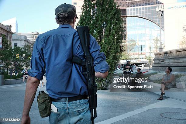 Man walks with an assault rifle near the site of the Republican National Convention in downtown Cleveland on the third day of the convention on July...