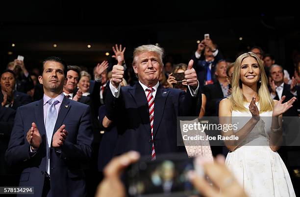 Republican presidential candidate Donald Trump gives two thumbs up as Donald Trump Jr. And Ivanka Trump stand and cheer for Eric Trump as he delivers...