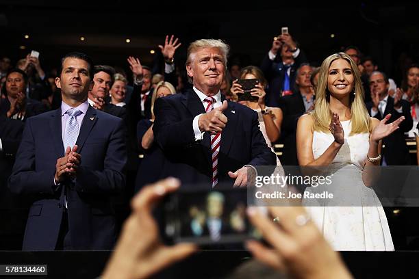 Republican presidential candidate Donald Trump gives a thumbs up as Donald Trump Jr. And Ivanka Trump stand and cheer for Eric Trump as he delivers...