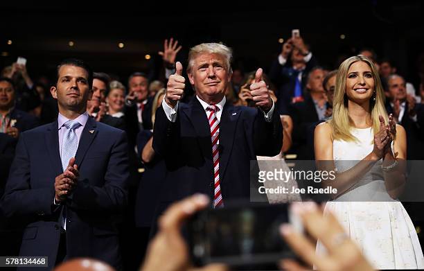 Republican presidential candidate Donald Trump gives two thumbs up as Donald Trump Jr. And Ivanka Trump stand and cheer for Eric Trump as he delivers...