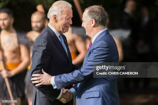 Vice President Joe Biden shakes hands with New Zealand Prime Minister John Key during a welcoming ceremony at Government House in Auckland on July...