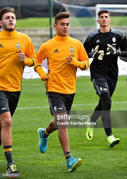 Juventus footballer Paulo Dybala runs a lap of the ground during a warm up drill before a Juventus FC training session at Lakeside Stadium on July...