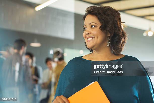 smiling businesswoman in office - creative collaboration holding stockfoto's en -beelden