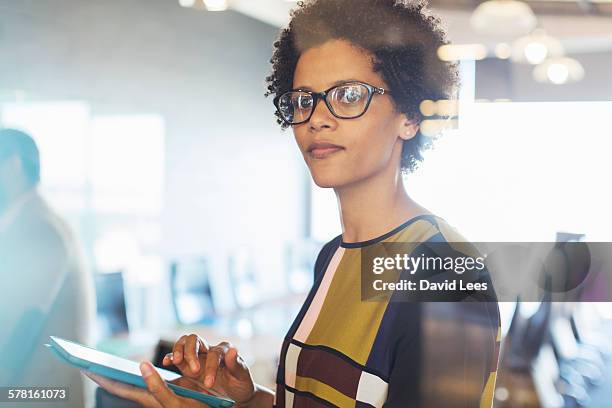 businesswoman using digital tablet in office - leanincollection foto e immagini stock