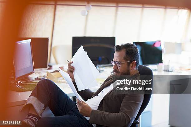 businessman reviewing paperwork in office - south africa map stockfoto's en -beelden