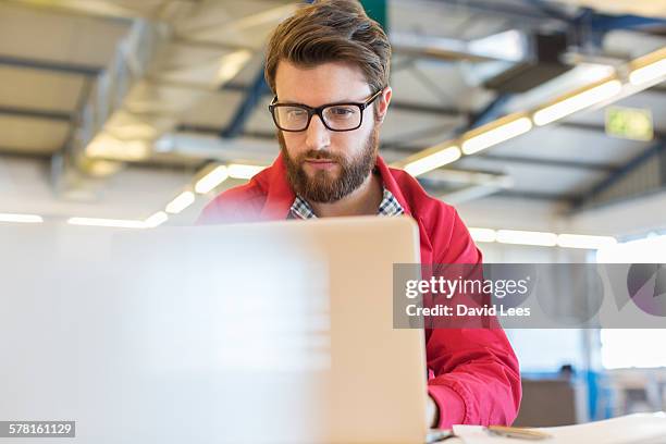 businessman using laptop in office - wear red day - fotografias e filmes do acervo