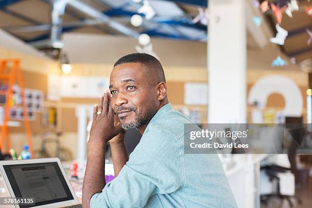 businessman using laptop in office - mature adult focus on foreground stock-fotos und bilder