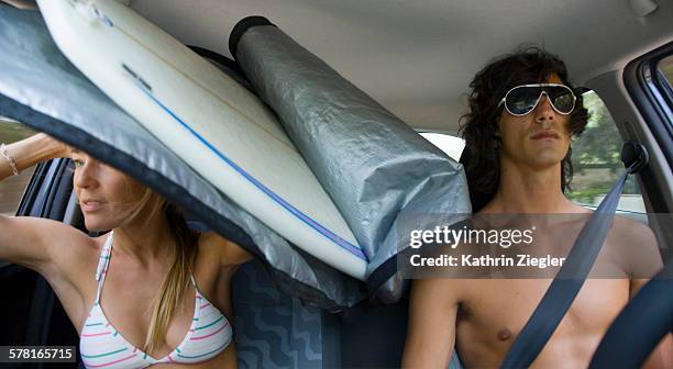 couple in a car with surfboard - man mid 20s warm stock pictures, royalty-free photos & images