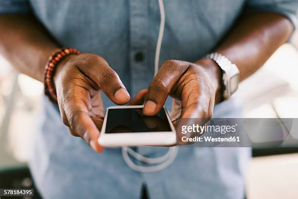 man holding smartphone - black hand holding phone stock-fotos und bilder