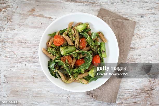 wholemeal spelt rigatoni with green asparagus, cherry tomato and rocket pesto on plate - pasta entree stock-fotos und bilder