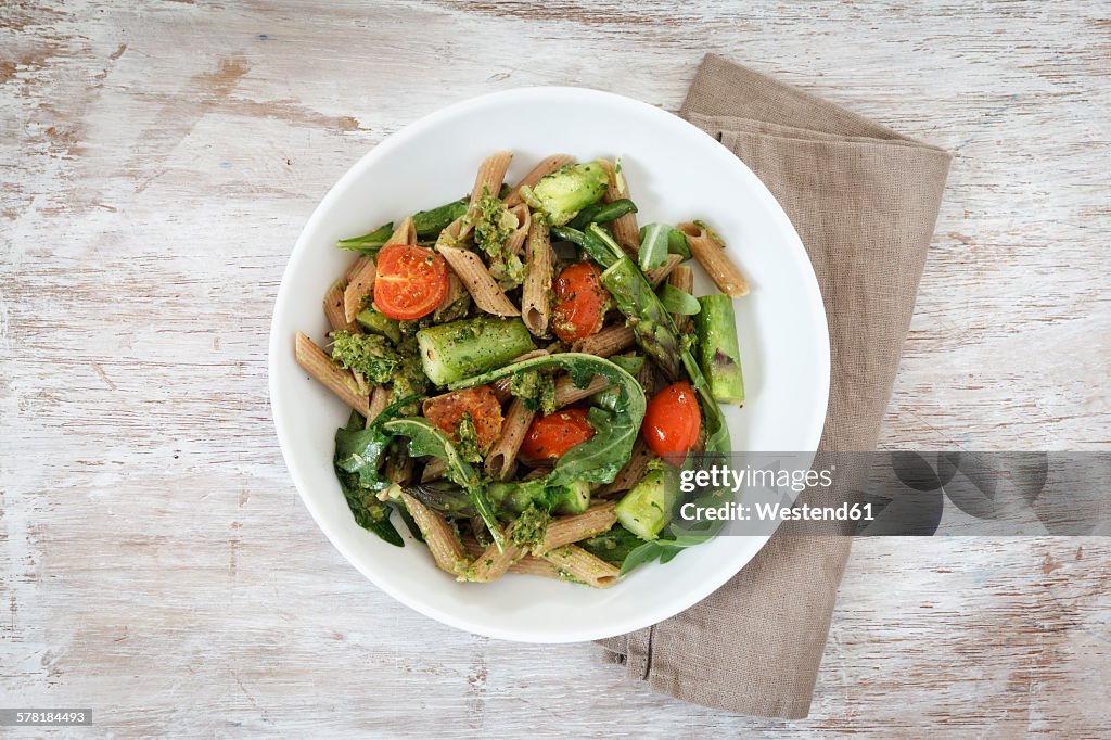 Wholemeal spelt rigatoni with green asparagus, cherry tomato and rocket pesto on plate