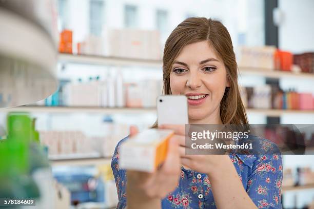 portrait of woman comparing products in a pharmacy - cosmetic testing store stock pictures, royalty-free photos & images