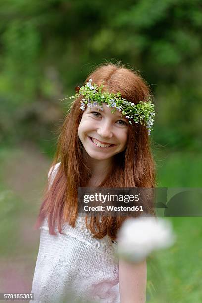 portrait of smiling girl wearing floral wreath - blumen als accessoire stock-fotos und bilder