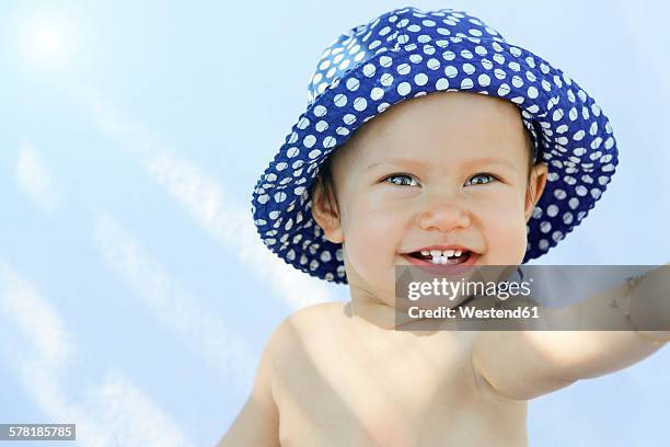 greece, kos, smiling baby girl with sun hat - baby sun hat stock-fotos und bilder