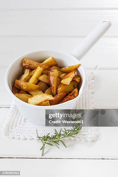 casserolle of potato wedges with rosemary - potato wedges stock pictures, royalty-free photos & images