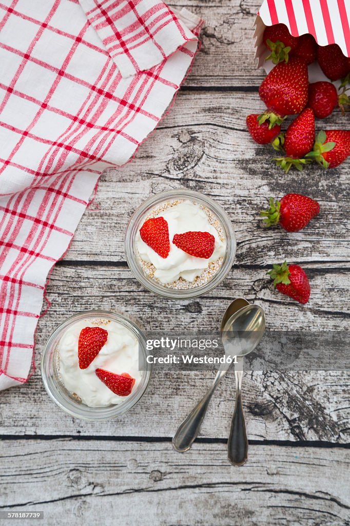 Granola, popped amarant, strawberries and yogurt in glasses