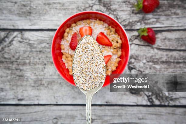 granola, popped amarant on spoon, strawberries and bowl - amarant stock pictures, royalty-free photos & images