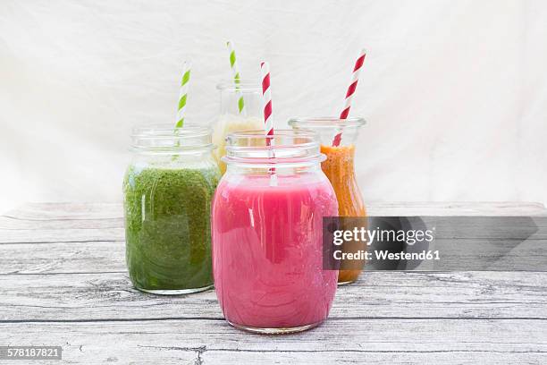 four glasses of different smoothies - fruit smoothies stock pictures, royalty-free photos & images