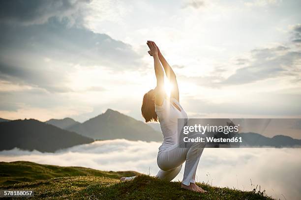 austria.kranzhorn, mid adult woman practising yoga on mountain top - sun salutation stock pictures, royalty-free photos & images