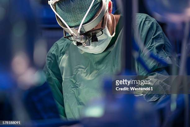 surgeon during a surgery - opération chirurgicale photos et images de collection