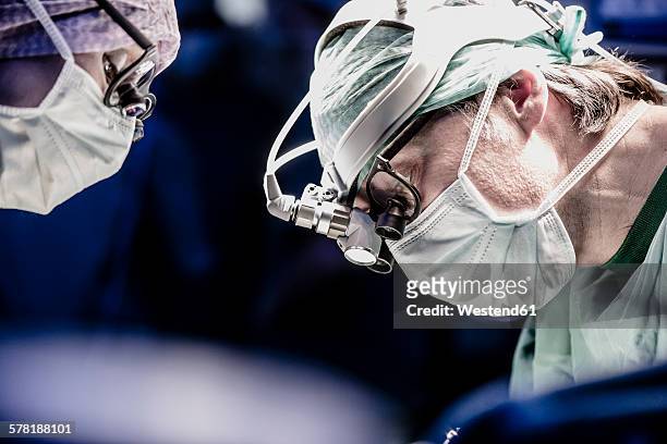 two surgeons during a surgery - operating room foto e immagini stock