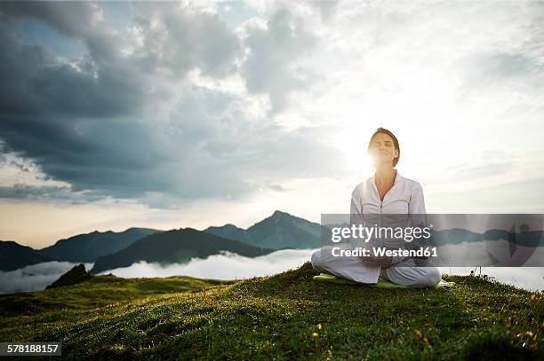 austria.kranzhorn, mid adult woman practising yoga on mountain top - spirituality nature stock pictures, royalty-free photos & images