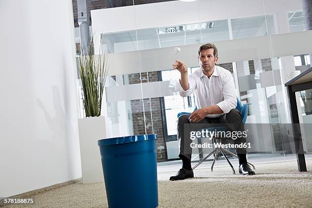 businessman in office throwing crumpled paper in wastepaper basket - wastepaper basket stock-fotos und bilder