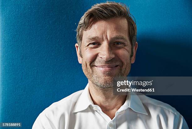 portrait of a confident businessman - man blue background stockfoto's en -beelden