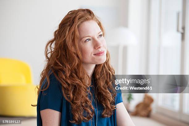 portrait of daydreaming young woman at home - woman looking up stockfoto's en -beelden