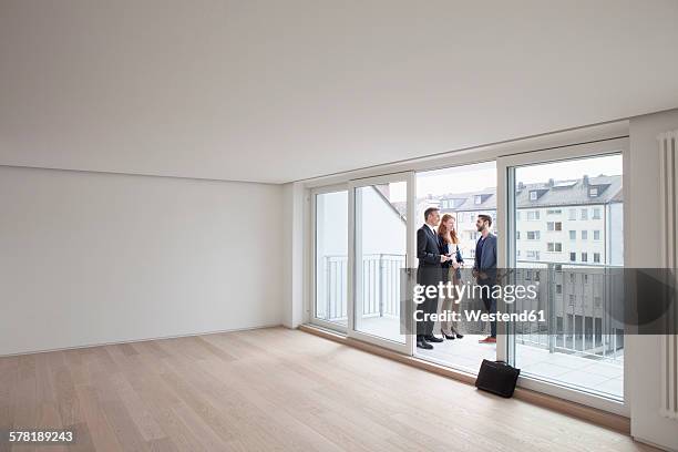 young couple viewing flat with estate agent - immobilienmakler stock-fotos und bilder