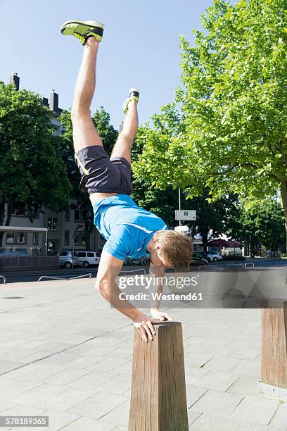 athlete doing a handstand on a bollard - ボラード ストックフォトと画像