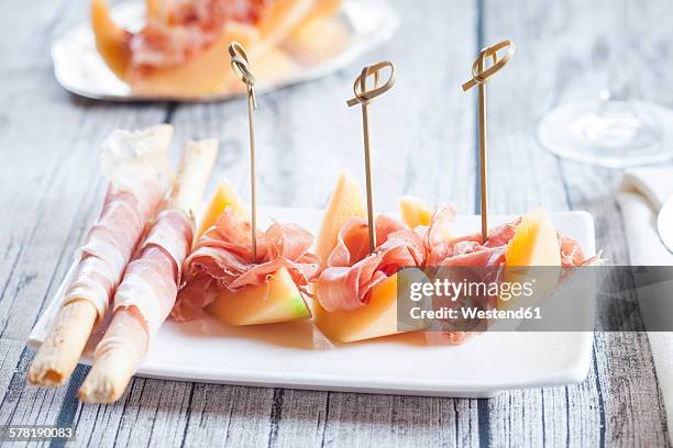 plate of charentais melon slices with ham and grissini wrapped with ham - rockmelon stock pictures, royalty-free photos & images