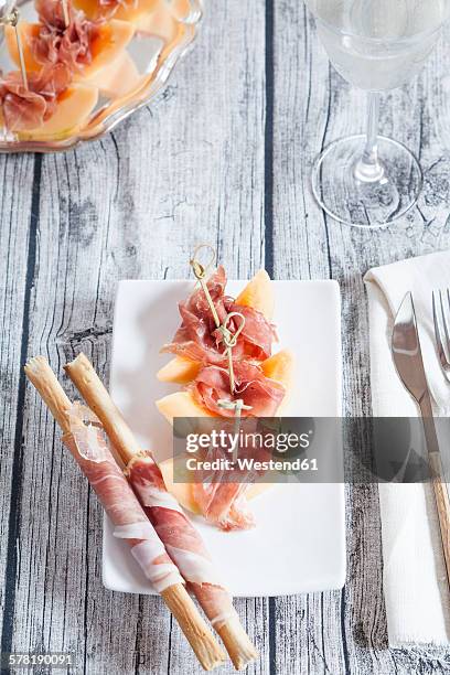 plate of charentais melon slices with ham and grissini wrapped with ham - rockmelon stock pictures, royalty-free photos & images