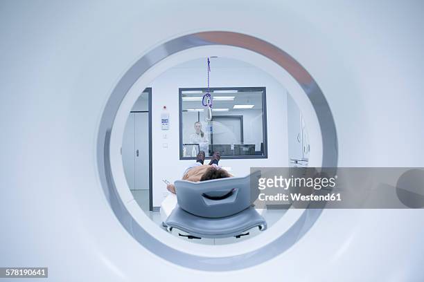 young doctor with patient at mri scanner - magnetresonanztomographie stock-fotos und bilder