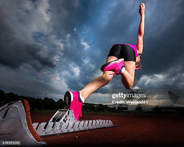 sprinter starting under cloudy sky - atletismo en pista femenino fotografías e imágenes de stock