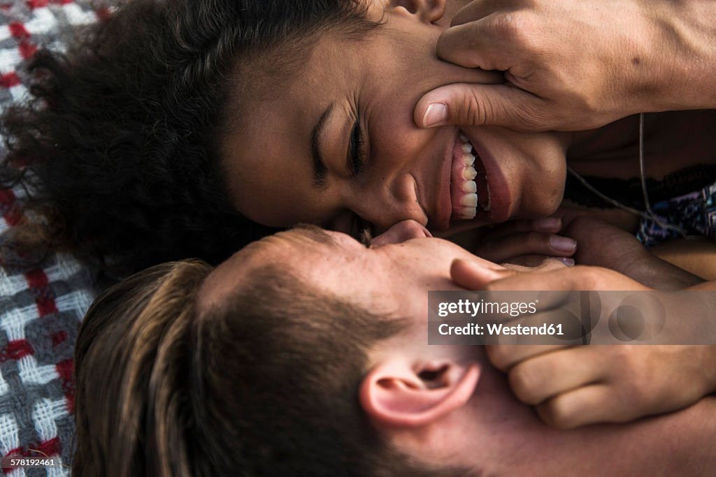 Intimate young couple lying on blanket