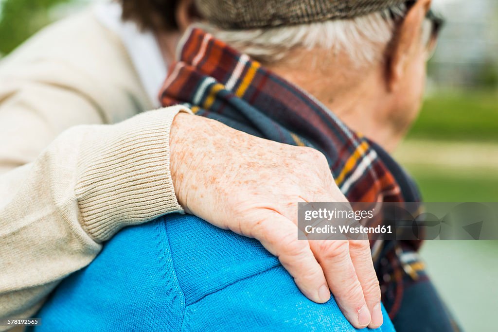 Hand of senior woman on shoulder of her husband