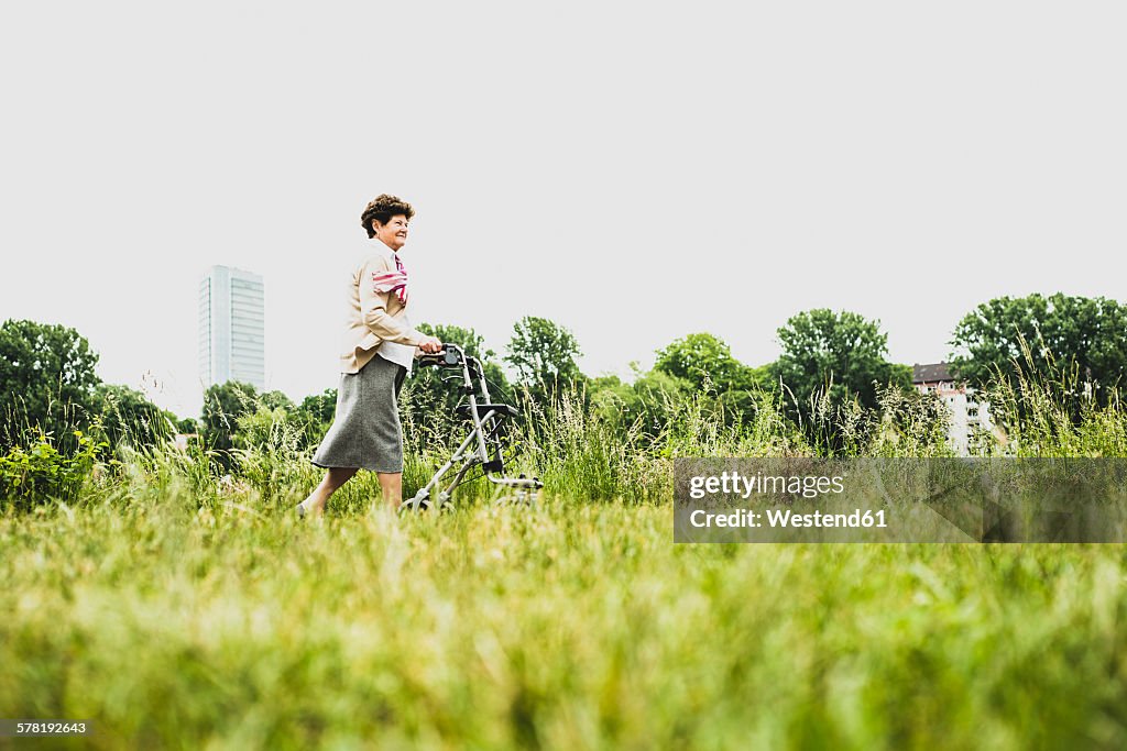Senior woman walking with wheeled walker