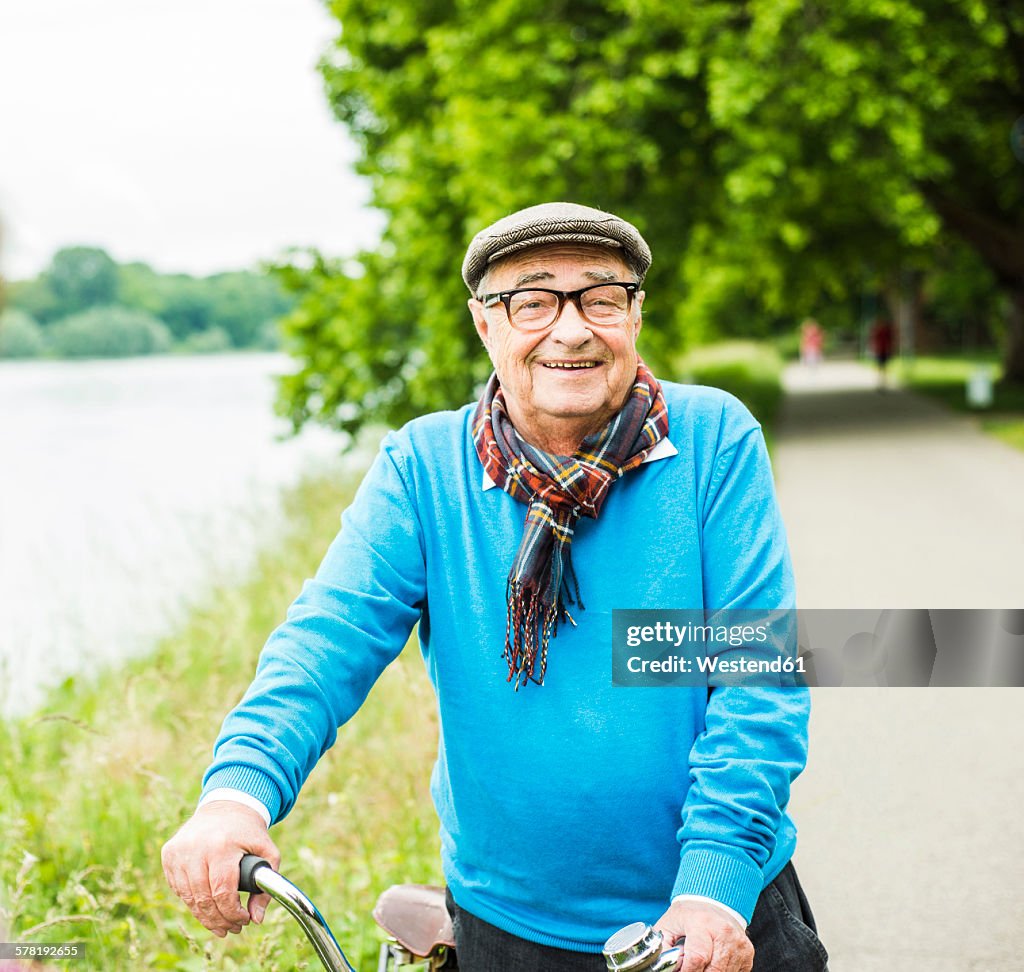 Portrait of happy senior man on his bicycle