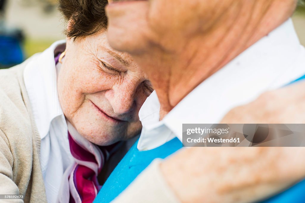 Happy senior woman with head on the shoulder of her husband