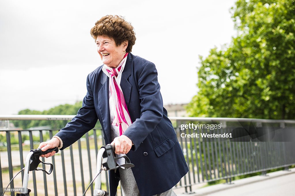 Smiling senior woman walking with wheeled walker