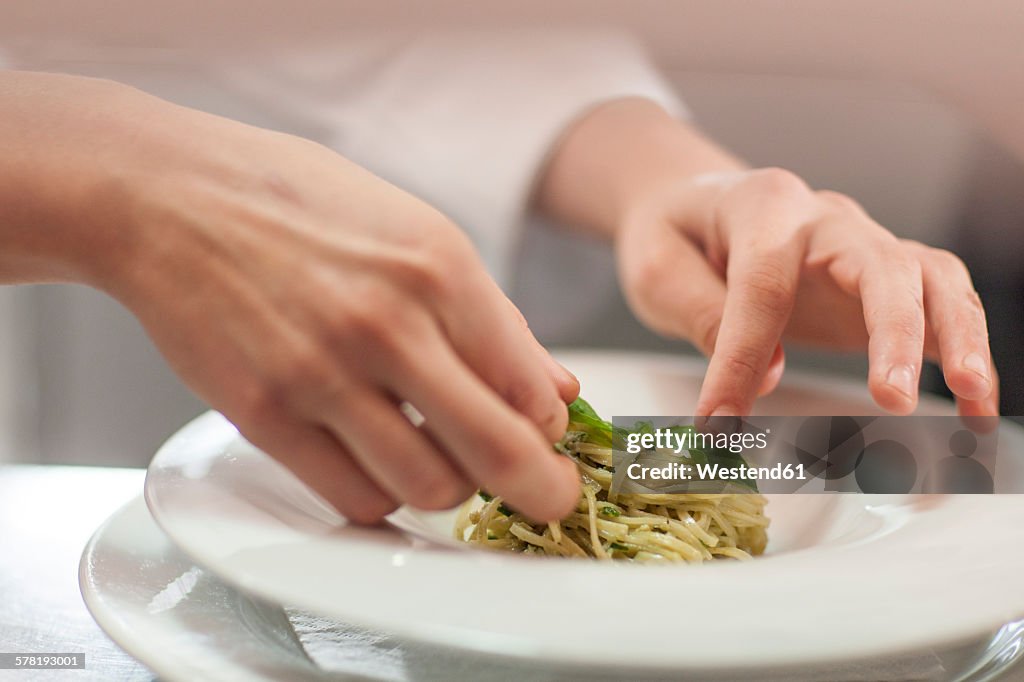 Chef garnishing plate with food