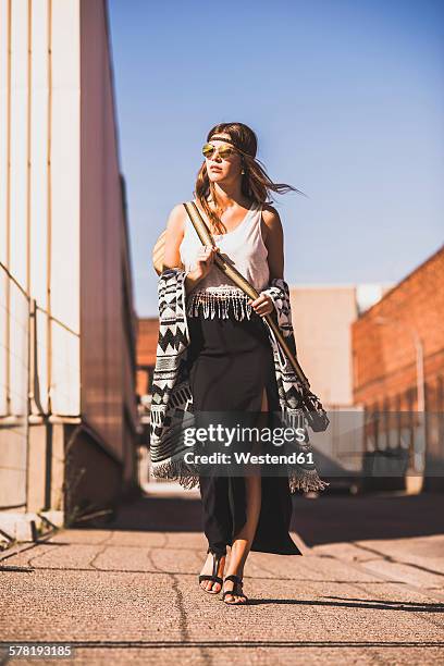 young woman wearing boho style walking on street - boho stock pictures, royalty-free photos & images
