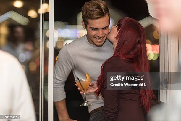 young woman with cocktail glass communicating with young man in a bar - verführung stock-fotos und bilder