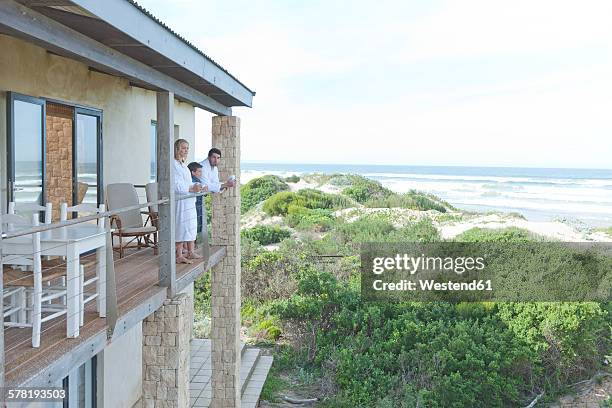 family on patio of beach house - beach house balcony fotografías e imágenes de stock