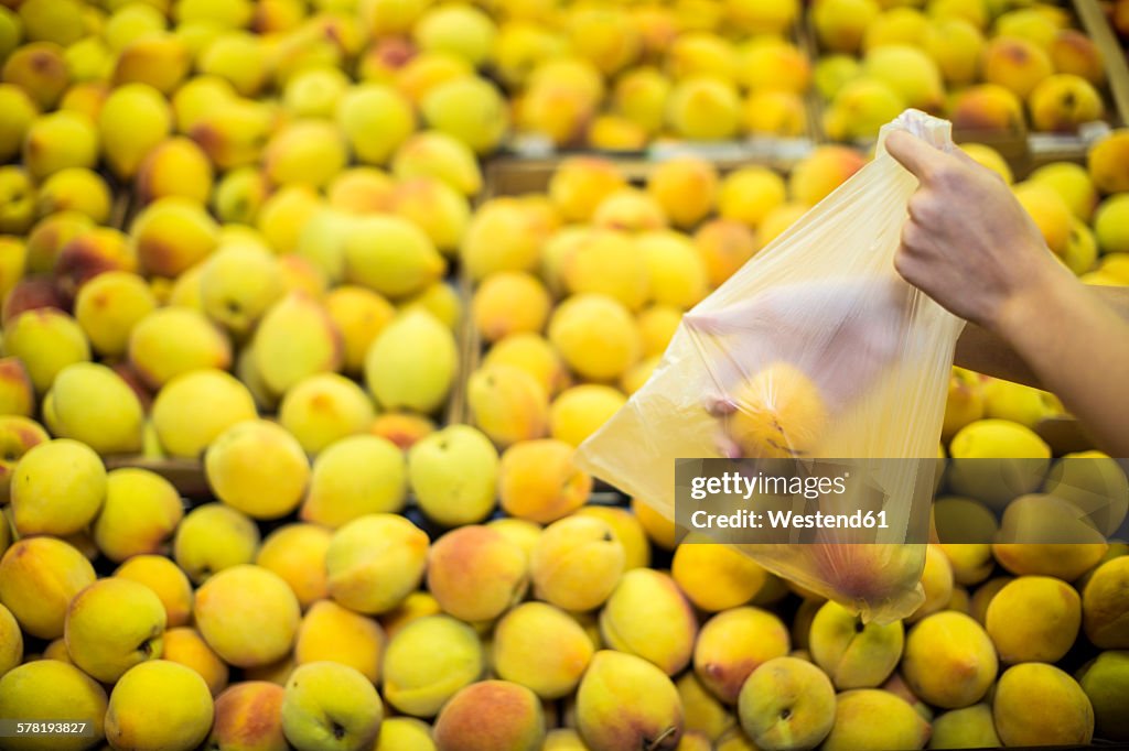 Hand picking peaches at fruit stall