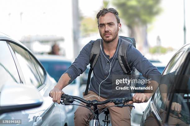 man on bicycle in traffic jam - velofahren stock-fotos und bilder