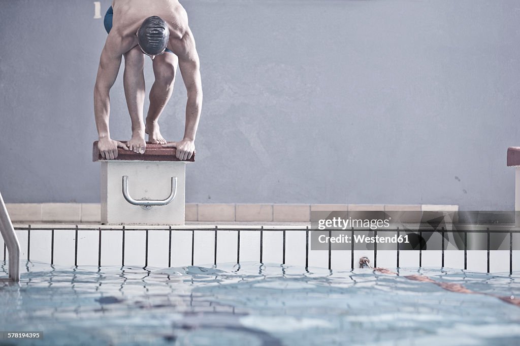 Swimmer in indoor pool in starting position