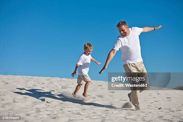 playful father and son in sand - 飛行機のまね ストックフォトと画像