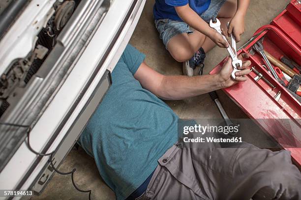 son helping father in home garage working on car - car toolbox stock pictures, royalty-free photos & images